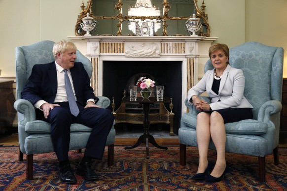 FILE - In this Monday. July 29, 2019 file photo, Scotland&#039;s First Minister Nicola Sturgeon, right, sits with Britain&#039;s Prime Minister Boris Johnson, in Bute House, ahead of their meeting, in ...
