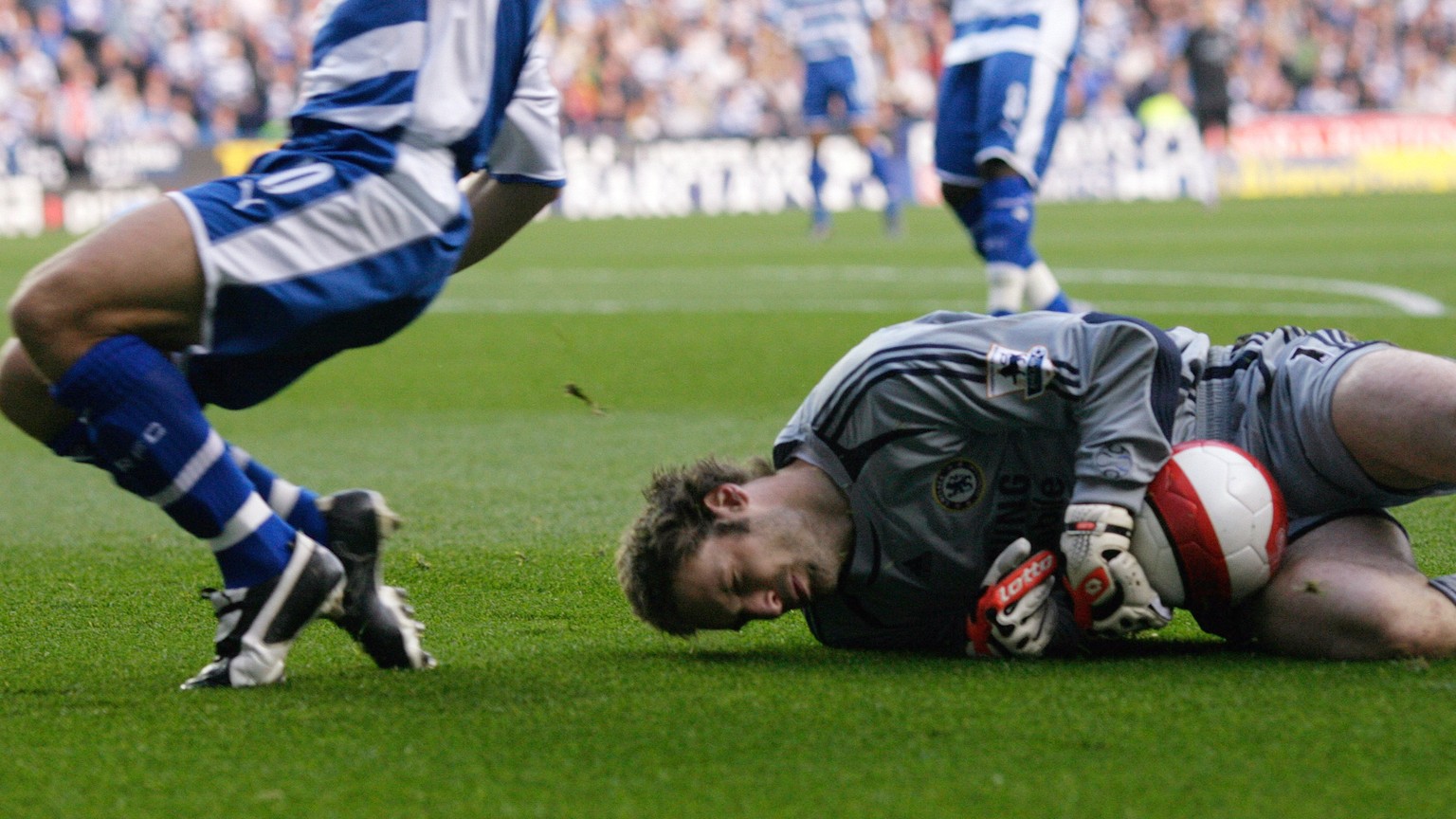 Chelsea&#039;s goalkeeper Petr Cech lies on the ground after a challenge by Reading&#039;s Stephen Hunt (L) in their English Premier League soccer match at the Madejski Stadium in Reading, southern En ...