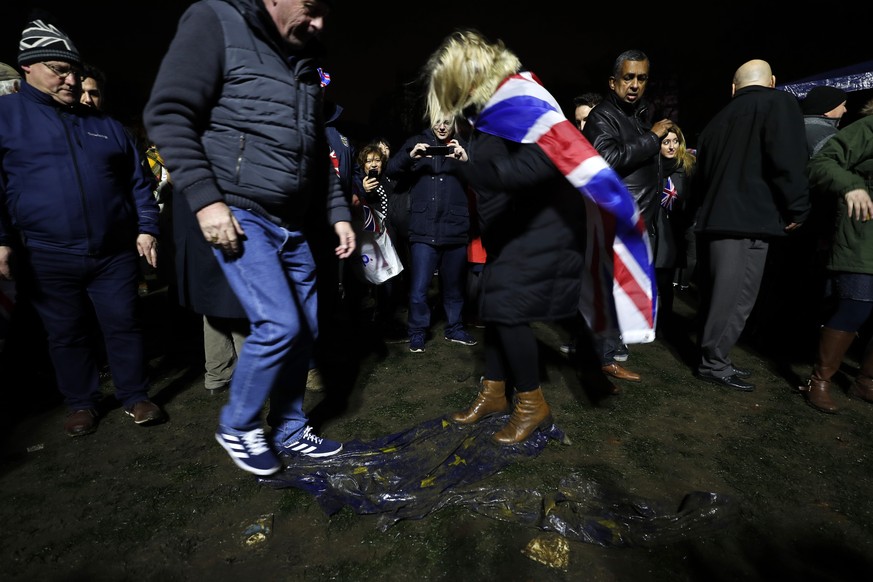 Brexit supporters trample on a European Union flag during a rally in London, Friday, Jan. 31, 2020. Britain officially leaves the European Union on Friday after a debilitating political period that ha ...
