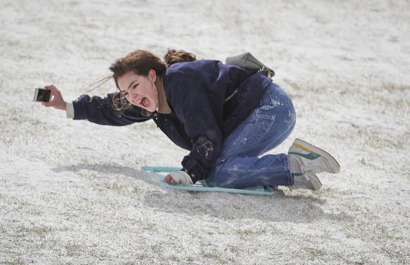 Rice University students Belen Szentes documents her sled ride on the Miller Outdoor Theatre hill Monday, Feb. 15, 2021, in Houston. A winter storm making its way from the southern Plains to the North ...
