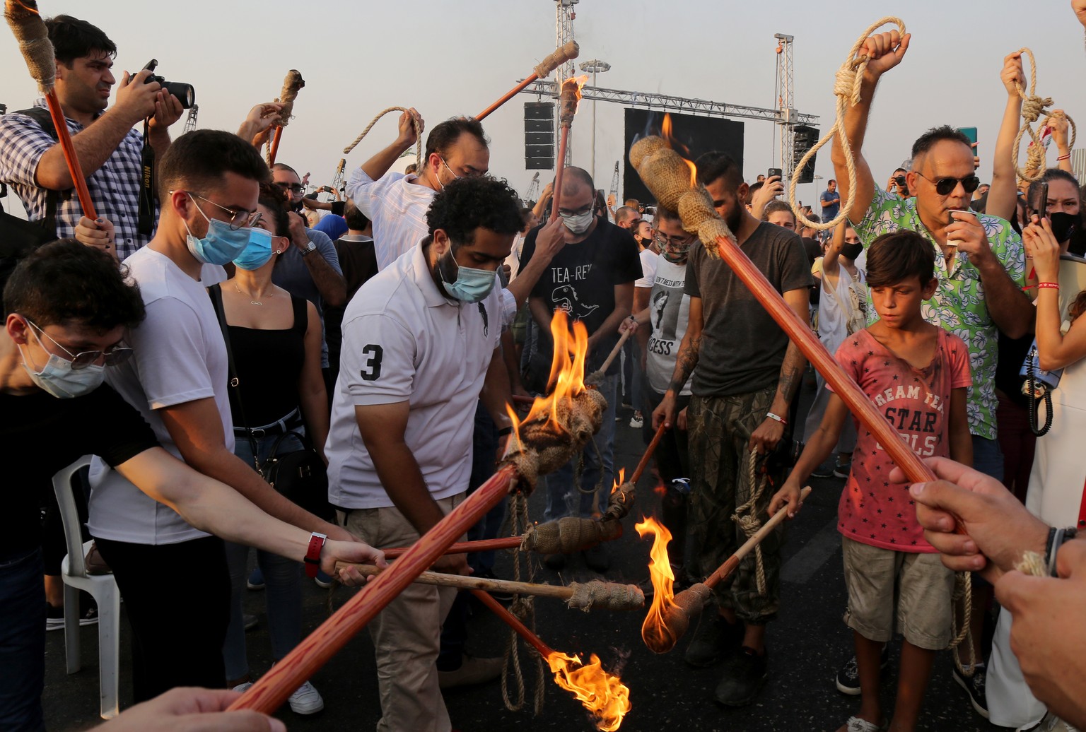 epa08647624 Anti- government protesters carry torches and hangman noose as they demand the punishment of those responsible for the port explosion, during a moment of silence to mark one month of Beiru ...