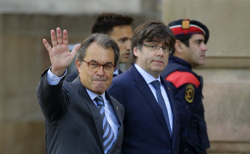 FILE- In this Monday, May 8, 2017 file photo, former Catalan president Artur Mas, left, waves to the crowd next to the then Catalan regional President Carles Puigdemont at the main entrance of the cou ...