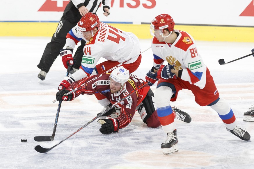 Russia&#039;s defender Damir Sharipzyanov, left, vies for the puck with Switzerland&#039;s forward Tanner Richard, center and Russia&#039;s defender Ziyat Paygin, right, during the ice hockey tourname ...