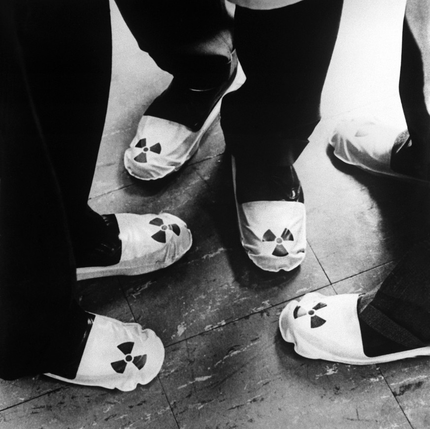 Themenbild zu Strahlenschutz in der Industrie. Die Aufnahme von 1961 zeigt drei Paar Fuesse in Strahlenschutz-Kleidung mit aufgedrucktem Atom-Zeichen. (KEYSTONE/PHOTOPRESS-ARCHIV/RIA/Str)