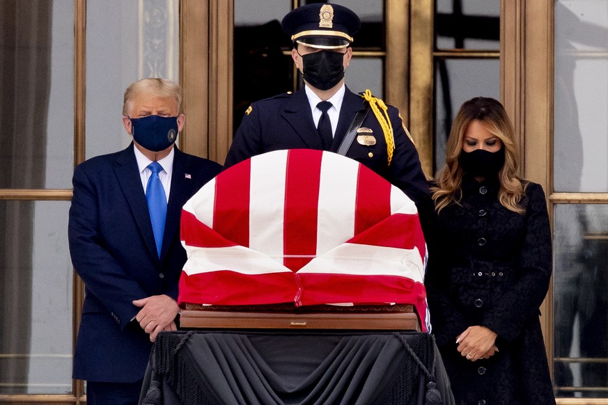 epaselect epa08693524 US President Donald J. Trump (L) and First Lady Melania Trump (R) view the flag-draped casket of late US Supreme Court Justice Ruth Bader Ginsburg outside the Supreme Court, in W ...