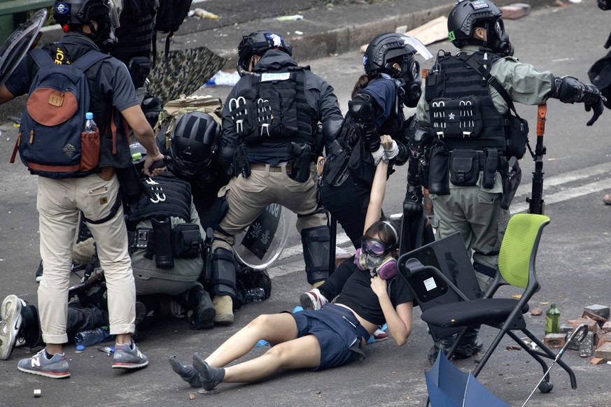 Police in riot gear drag a protester who was trying to flee from the Hong Kong Polytechnic University in Hong Kong, Monday, Nov. 18, 2019. Hong Kong police have swooped in with tear gas and batons as  ...