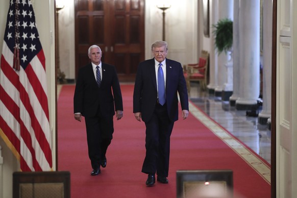 epa08544210 US President Donald J. Trump and Vice President Mike Pence walk in the grand foyer of the White House towards the East Room during a roundtable with stakeholders positively impacted by law ...