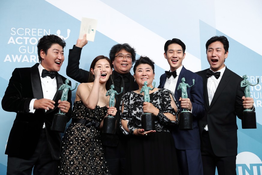 epaselect epa08143358 Director Bong Joon-ho (C) pose with his cast with the SAG Award for Outstanding performance by a cast in a motion picture in &#039;Parasite&#039; at the press room during the 26t ...