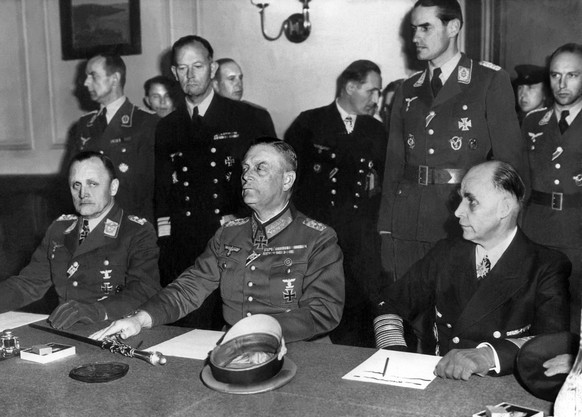 General Hans-Juergen Stumpf der Luftwaffe, links, Marschall Wilhelm Keitel der Wehrmacht, Mitte, und Admiral Hans-Georg von Friedeburg der deutschen Flotte, rechts, unterzeichnen am 9. Mai 1945 im sow ...