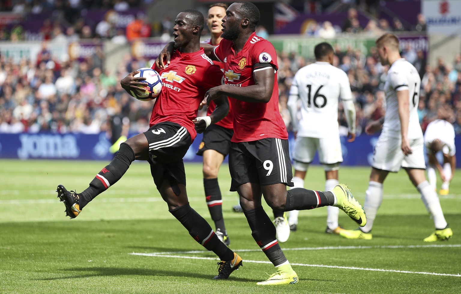 Manchester United&#039;s Eric Bailly, left, celebrates with teammate Romelu Lukaku after scoring his side&#039;s first goal during their English Premier League soccer match at the Liberty Stadium, Swa ...