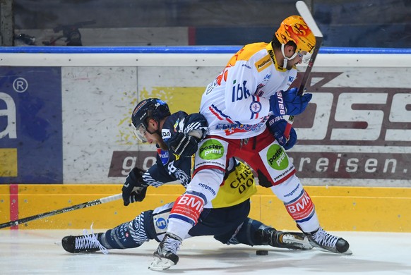 Ambri&#039;s player Jesse Zgraggen, left, fights for the puck with Kloten&#039;s player Vincent Praplan, right, during the preliminary round game of National League Swiss Championship 2017/18 between  ...