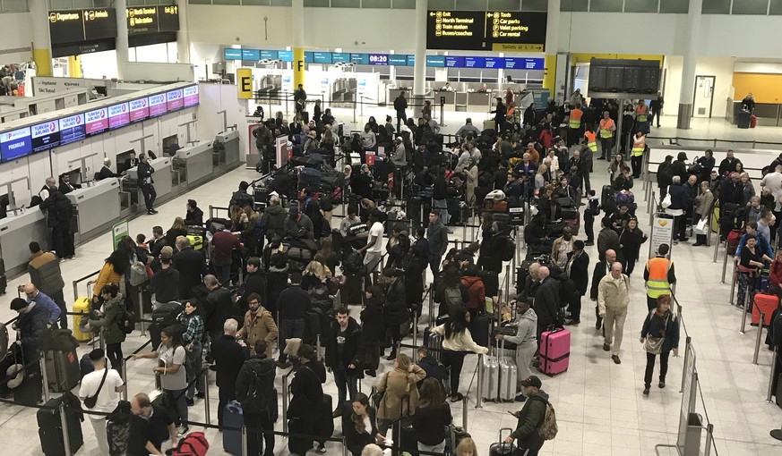 Passengers wait to check in at Gatwick Airport in England, Friday, Dec. 21, 2018. Flights resumed at London&#039;s Gatwick Airport on Friday morning after drones sparked the shutdown of the airfield f ...