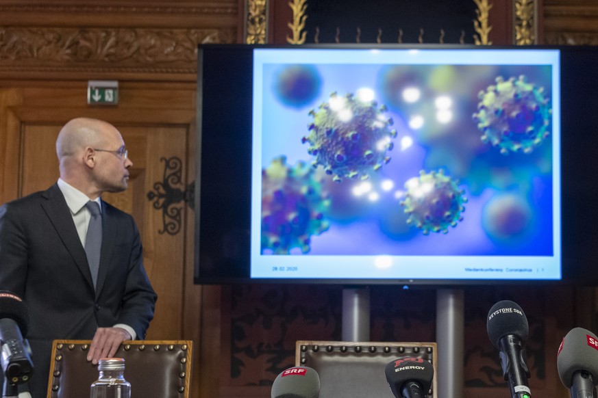 Regierungsrat Baschi Duerr, Justiz- und Sicherheitsdepartement, schaut auf eine Projektion mit dem Bild des Coronavirus an der Medienkonferenz im Rathaus in Basel, am Freitag, 28. Februar 2020. Der Re ...
