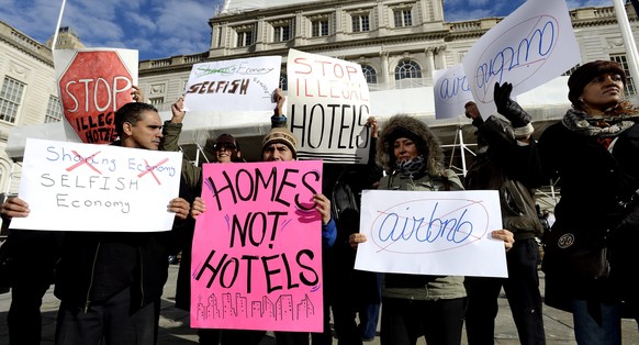 epa04571225 Detractors of Airbnb operations in New York hold signs during a rally at City Hall before a hearing on the subject of Airbnb in New York, New York, USA, 20 January 2015. The New York City  ...
