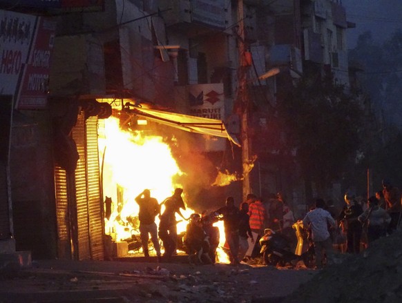 A shop is set on fire during violence between two groups in New Delhi, India, Tuesday, Feb. 25, 2020. At least 10 people were killed in two days of clashes that cast a shadow over U.S. President Donal ...