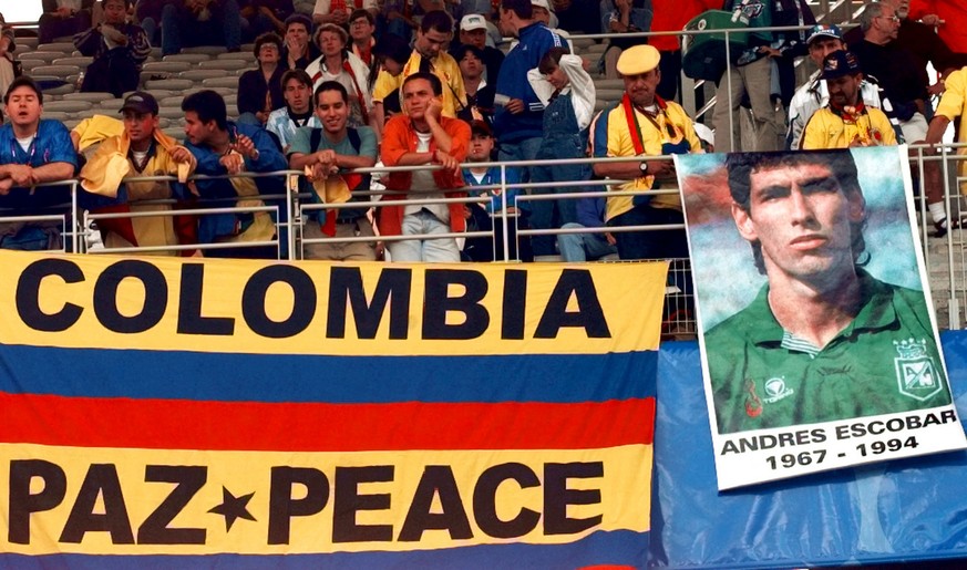 Colombian soccer fans display a flag which reads &quot;Colombia - Peace &quot; and a poster of player Andres Escobar who was killed in Medellin, Colombia, after Colombia was eliminated in the 1994 Wor ...