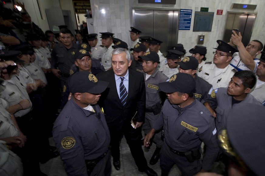 Otto Pérez Molina inmitten von Polizisten vor Gericht.
