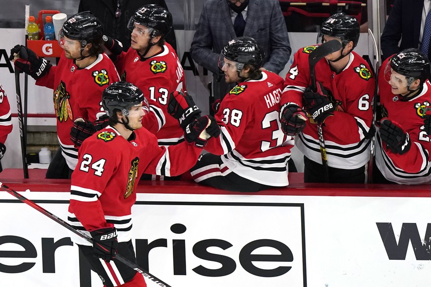 Chicago Blackhawks center Pius Suter (24) celebrates with teammates after scoring his first goal against the Detroit Red Wings Chicago Blackhawks during the first period of an NHL hockey game in Chica ...