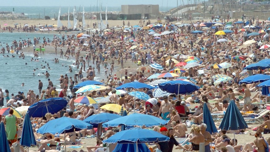 Thousands of people flock to the beach in Barcelona, Spain, to take the sun and enjoy the Mediterrenean, Sunday 04 July 2004 as temperatures rose into the mid-30s following several days of cooler weat ...