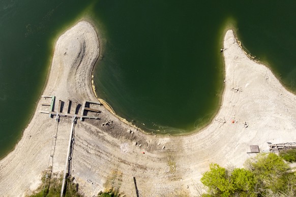 Boat docks are pictured on the dried out shore of the Lake of Gruyere in Rossens, Switzerland, Friday, April 17, 2020. The level of the artificial impounding reservoir is progressively being brought d ...