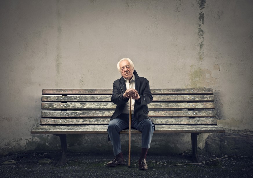 Alter Mann mit Stock auf einer Bank (Symbolbild)