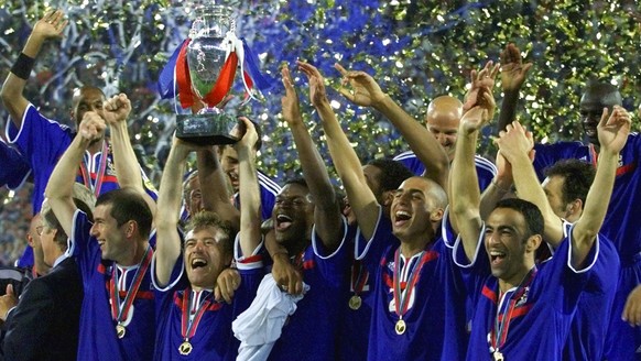 French soccer team captain Didier Deschamps, center, holds aloft the EURO 2000 Soccer Championships trophy after his team beat Italy 2-1 with a golden goal winner in extra time in the final at the De  ...