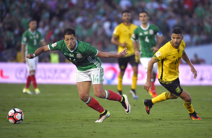 Mexico forward Chicharito, left, moves the ball as Jamaica midfielder Joel McAnuff pressures him during a Copa America group C soccer match at the Rose Bowl, Thursday, June 9, 2016, in Pasadena, Calif ...