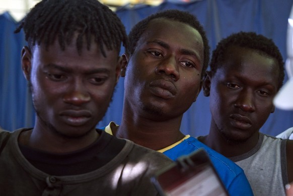 Migrants and refugees, aboard a ship, wait in line to be registered after being rescued, in the Mediterranean Sea off the coast of Libya Thursday, Oct. 20, 2016. More than 200 migrants and refugees we ...