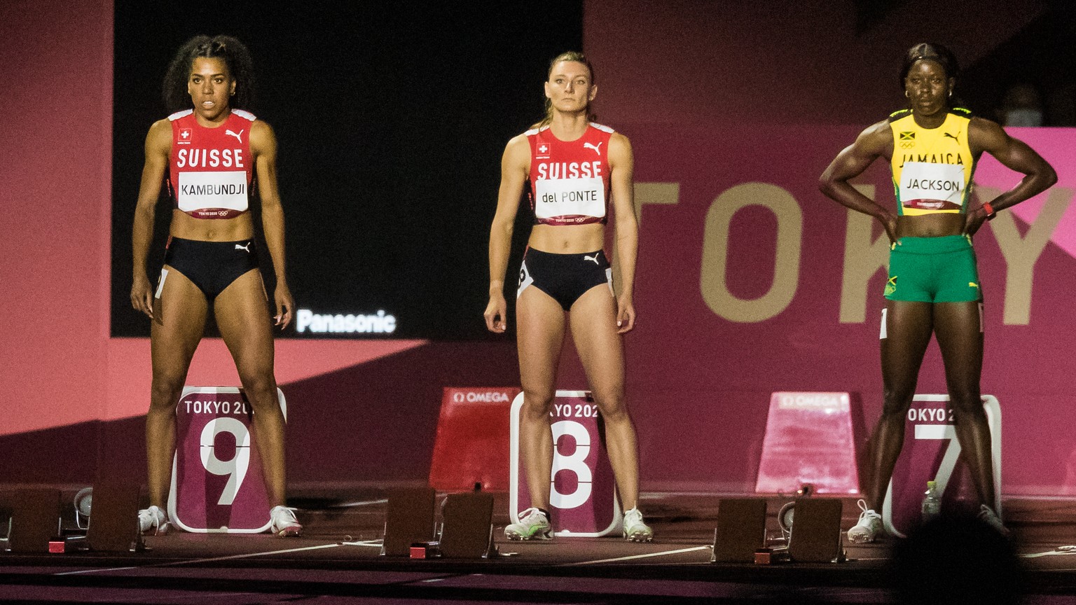 Mujinga Kambundji of Switzerland, left, Ajla Del Ponte of Switzerland, center, and Shericka Jackson of Jamaica, right, line up at the start of the women&#039;s 100 m final at the 2020 Tokyo Summer Oly ...