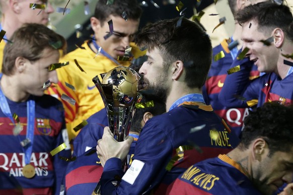 epa05076650 Barcelona&#039;s defender Gerard Pique kisses the trophy as he celebrates with teammates after winning the final match of the FIFA Club World Cup 2015 between FC Barcelona and River Plate  ...