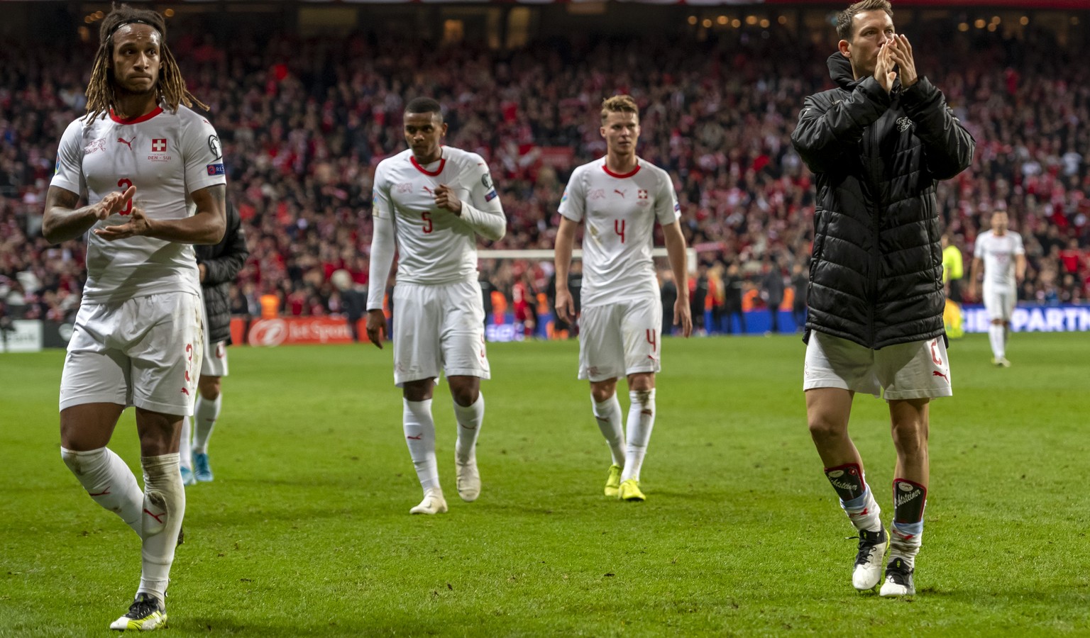 Switzerland&#039;s Kevin Mbabu, Manuel Akanji, Nico Elvedi and Stephan Lichtsteiner, from left, leave the pitch after the UEFA Euro 2020 qualifying Group D soccer match between Denmark and Switzerland ...