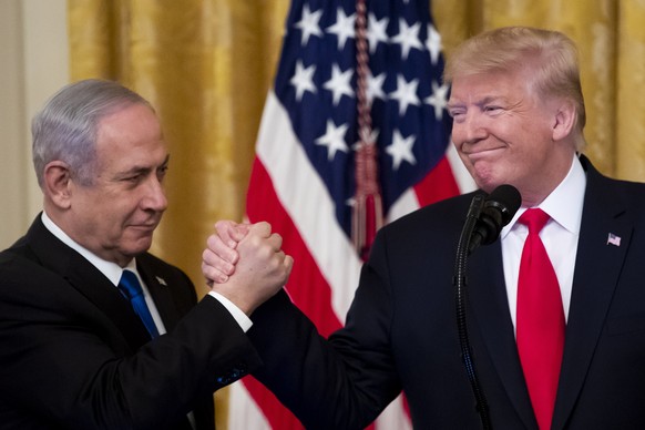 epa08173197 US President Donald J. Trump (R) shakes hands with Prime Minister of Israel Benjamin Netanyahu while unveiling his Middle East peace plan in the East Room of the White House, in Washington ...