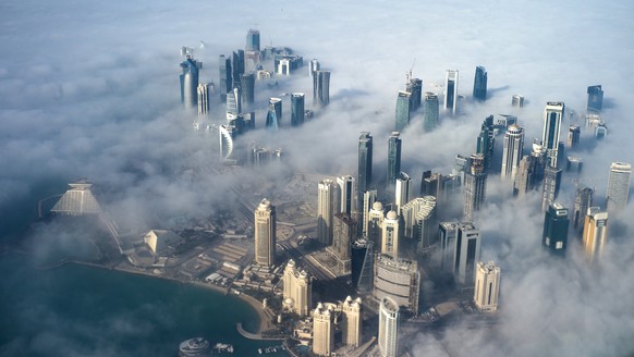 epa06052579 (FILE) - An aerial view of high-rise buildings emerging through fog covering the skyline of Doha, as the sun rises over the city, in Doha, Qatar, 15 February 2014 (reissued 27 June 2017).  ...