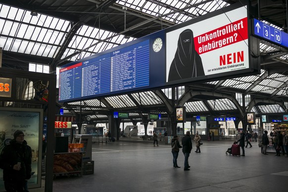 Im Hauptbahnhof haengen Plakate gegen die erleichterte Einbuergerung junger Auslaender, das Motiv ist eine mit einer Burka verschleierte Frau, am Montag, 9. Januar 2017 in Zuerich. Das Schweizer Stimm ...