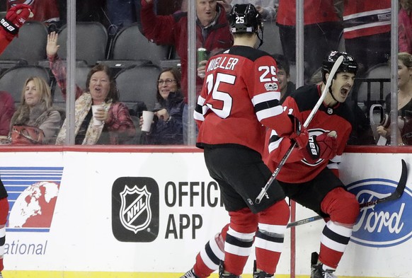New Jersey Devils center Brian Boyle, right, celebrates his first-period goal with teammates Mirco Mueller(25), of Switzerland, and Jimmy Hayes (10) during an NHL hockey game against the Edmonton Oile ...