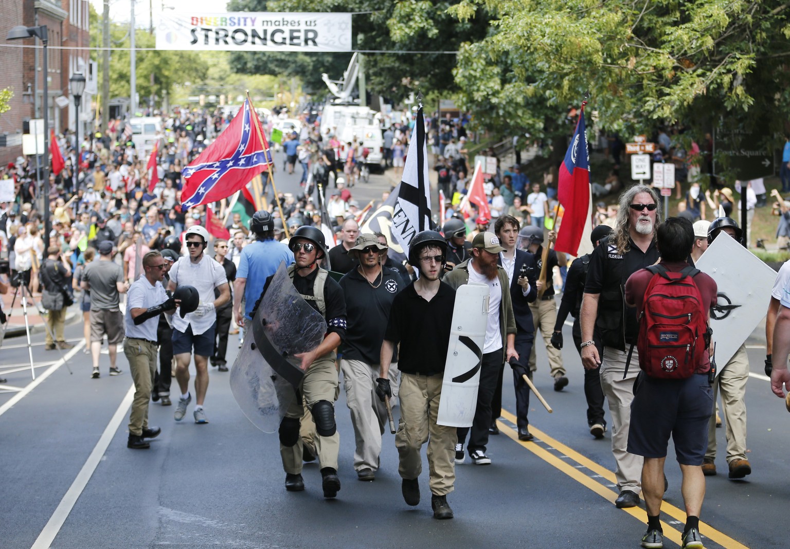 Alt Right demonstrators walk through town after their rally was declared illegal near Lee Park in Charlottesville, Va., Saturday, Aug. 12, 2017. (AP Photo/Steve Helber)