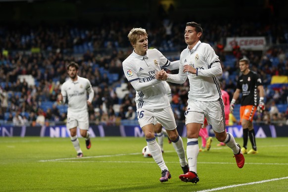 Real Madrid&#039;s James, right, celebrates with teammate Odegaard after scoring a goal, during the Spain&#039;s Copa del Rey, King&#039;s Cup soccer match between Real Madrid and Cultural Leonesa at  ...