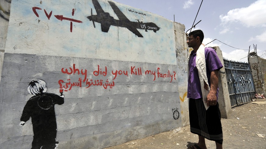 epa04158496 A Yemeni man looks at a graffiti protesting against US drone operations, in Sana’a, Yemen, 07 April 2014. Reports state Yemen has issued a temporary ban on US military drone strikes in the ...