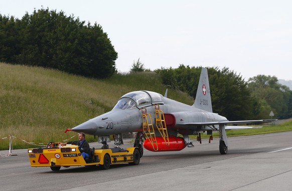 A Swiss Army staff member tows a F-5 Tiger fighter jet at the Swiss Air Force base in Payerne June 2, 2014. REUTERS/Denis Balibouse (SWITZERLAND - Tags: TRANSPORT MILITARY)
