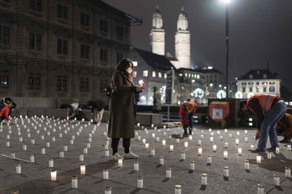 Initianten einer privaten Mahnwache zuenden 382 Kerzen fuer alle bisherigen Todesopfer der Coronavirus-Pandemie im Kanton Zuerich an, auf der Rathausbruecke, am Freitag, 27. November 2020, in Zuerich. ...