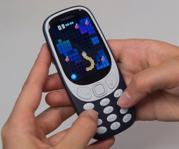 Ein Mann spielt am 24.05.2017 in London (Großbritannien) auf einem Nokia 3310 den Handyspiel-Klassiker «Snake». Der finnische Anbieter HMD Global, der jetzt Geräte unter der Marke Nokia entwickelt und ...