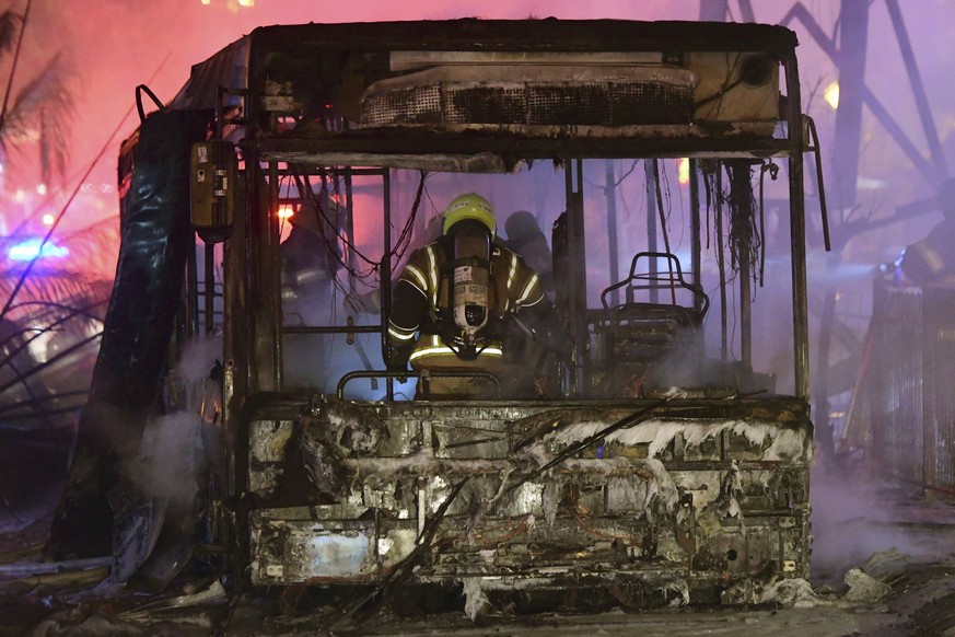 An Israeli firefighter extinguishes a burning bus after it was hit by a rocket fired from the Gaza Strip, at the central Israeli town of Holon, near Tel Aviv, Tuesday, May 11, 2021. (AP Photo/Avshalom ...