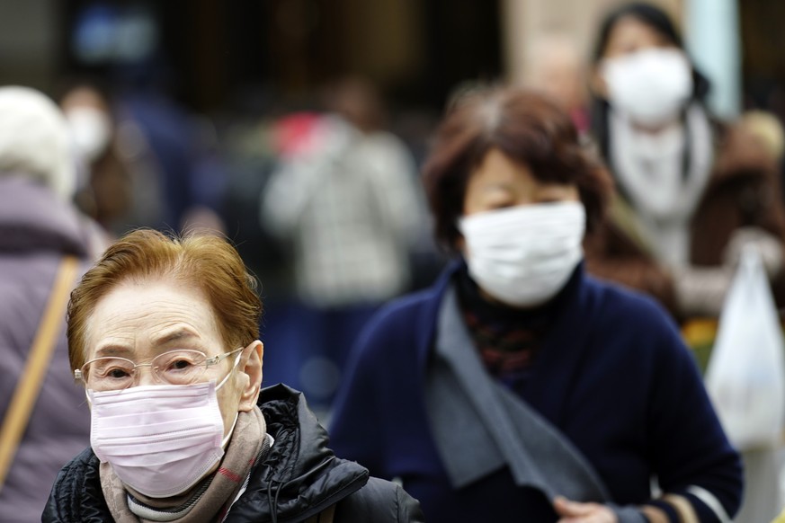 Pedestrians wear protective masks as they walk through a shopping district in Tokyo Thursday, Jan. 16, 2020. Japan&#039;s government said Thursday a man treated for pneumonia after returning from Chin ...