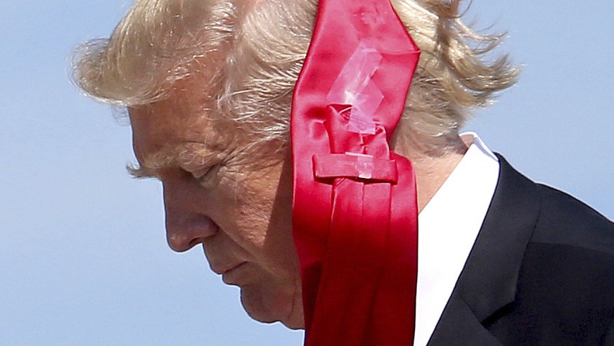 Wind blows President Donald Trump&#039;s tie as he arrives at Orlando International Airport for a visit to St. Andrew Catholic School in Orlando, Fla., Friday, March 3, 2017. (Joe Burbank/Orlando Sent ...