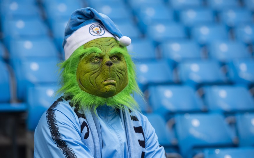 epa07244871 A Manchester City fan wearing grinch mask and wearing Christmas hat reacts before the English Premier League soccer match between Manchester City and Crystal Palace at the The Etihad Stadi ...