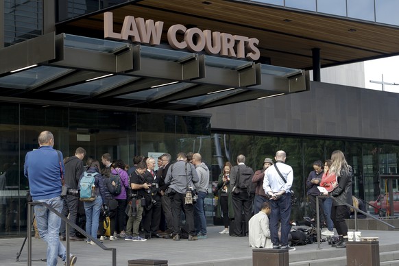 Members of the media wait outside the district court building for word on the man arrested in connection with the mass shootings at two mosques in Christchurch, New Zealand, Saturday, March 16, 2019.  ...