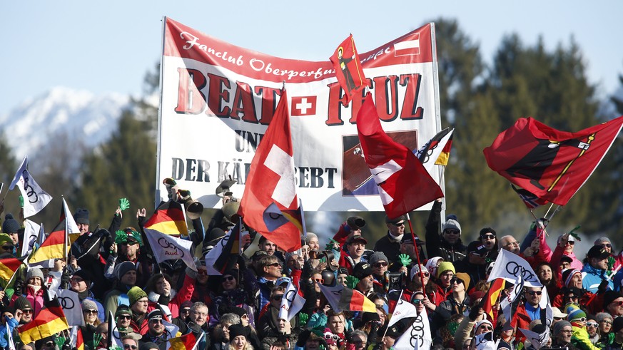 Swiss Beat Feuz supporters stand on the tribune gets to the finish area after completing alpine ski, men&#039;s World Cup downhill, in Garmisch-Partenkirchen, Germany, Saturday, Jan. 27, 2018. (AP Pho ...