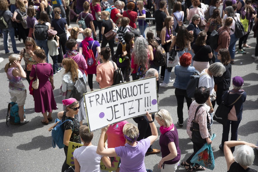 Eine Teilnehmerin haelt ein Plakat mit der Aufschrift “Frauenquote jetzt“, bei einer Kundgebung zum Frauenstreik auf dem Bundesplatz, am Freitag, 14. Juni 2019 in Bern. (KEYSTONE/Peter Klaunzer)