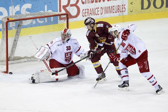 Lausanne&#039;s goaltender Pascal Caminada, left, saves a puck past Geneve-Servette&#039;s forward Jeremy Wick, center, and Lausanne&#039;s defender Dario Trutmann, right, during the game of National  ...