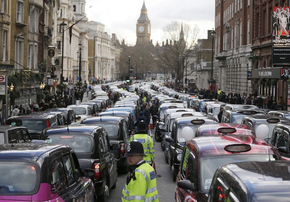 FILE - In this Wednesday, Feb. 10, 2016 file photo, London taxis block the roads during a protest in central London, concerned with unfair competition from services such as Uber. LondonÄôs transit op ...